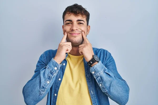 Jovem Hispânico Sobre Fundo Azul Sorrindo Com Boca Aberta Dedos — Fotografia de Stock