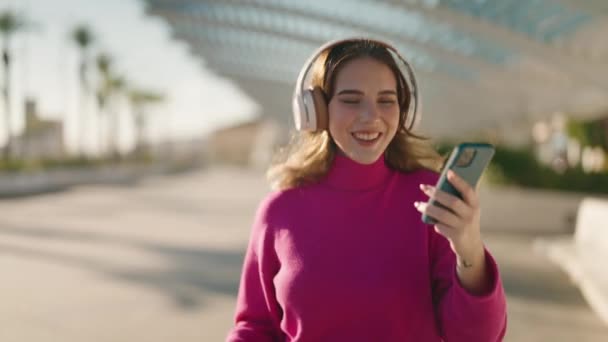 Jovem Loira Sorrindo Confiante Ouvir Música Andando Parque — Vídeo de Stock