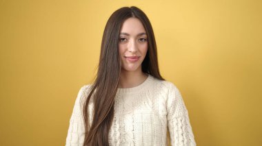 Young beautiful hispanic woman smiling confident standing over isolated yellow background