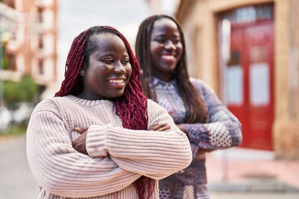 アフリカ系アメリカ人の女性の友人笑顔自信を持って立って腕で交差ジェスチャーで通り — ストック写真
