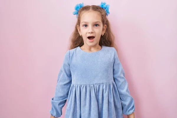 Junges Kleines Mädchen Steht Über Rosa Hintergrund Verängstigt Und Erstaunt — Stockfoto