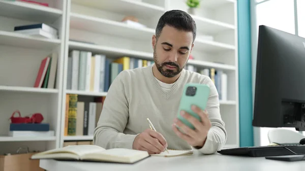 Mladý Hispánec Muž Student Pomocí Smartphone Psaní Notebooku Knihovně Univerzity — Stock fotografie