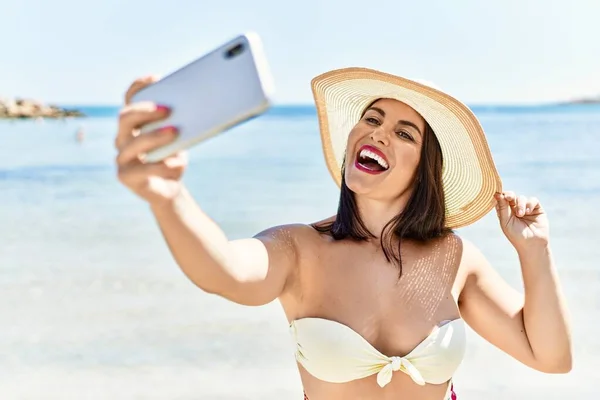 若いです美しいですヒスパニック女性観光笑顔自信を持って作るSlefieによってスマートフォンで海辺 — ストック写真