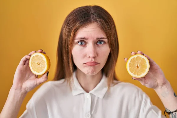 Beautiful woman holding lemons depressed and worry for distress, crying angry and afraid. sad expression.