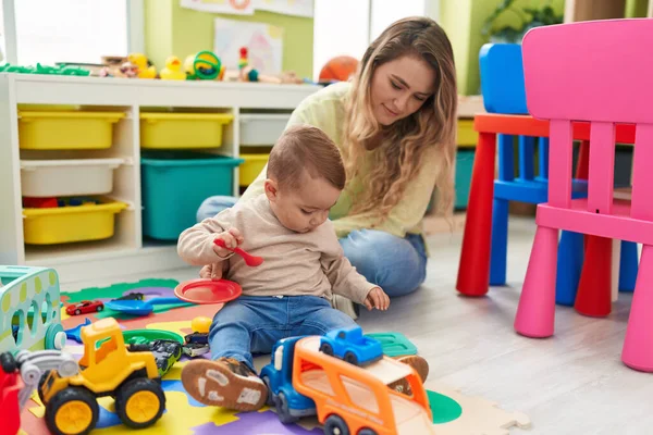 Öğretmen Bebek Arabalarla Oynuyor Anaokulunda Yerde Oturuyor — Stok fotoğraf