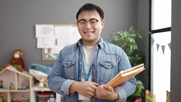Молодой Китайский Учитель Улыбается Уверенно Держа Книги Детском Саду — стоковое фото