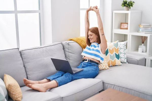 Jonge Roodharige Vrouw Met Behulp Van Laptop Stretching Armen Zitten — Stockfoto