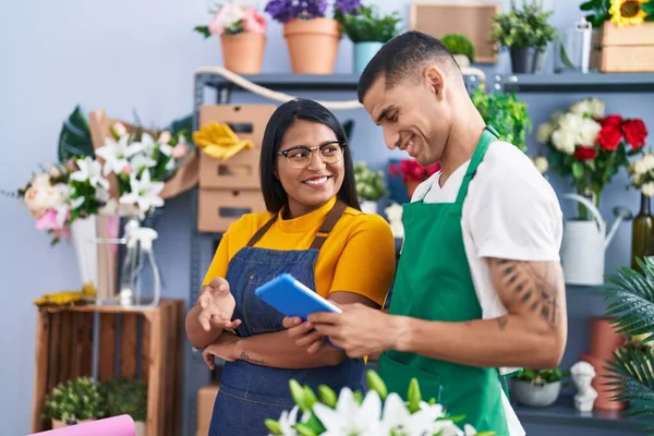Man and woman florists smiling confident using touchpad at florist