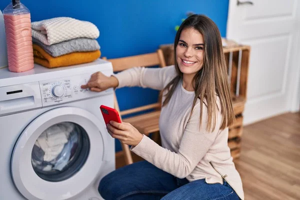 Young Beautiful Hispanic Woman Turning Washing Machine Using Smartphone Laundry — Stock Photo, Image