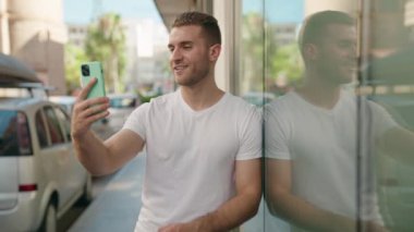 Genç, beyaz bir adam gülümsüyor.