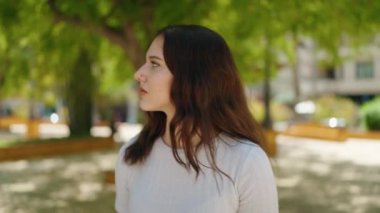 Parkta rahat bir ifadeyle yürüyen genç kadın.