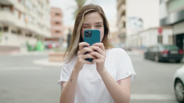 Młoda Kobieta Uśmiecha Się Pewnie Robiąc Zdjęcie Przez Smartfona Ulicy — Wideo stockowe