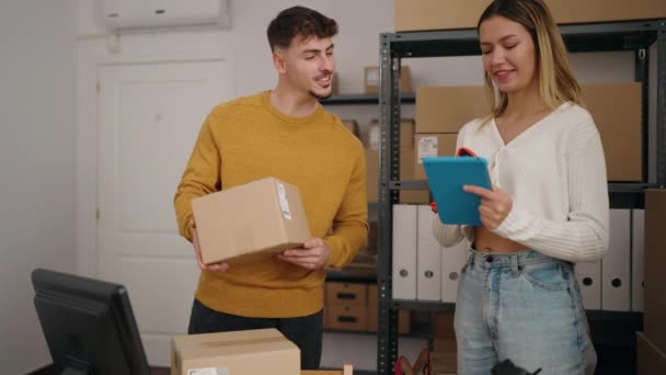 若いカップル電子商取引労働者はオフィスでバーコードリーダを使用してパッケージをスキャンする — ストック動画