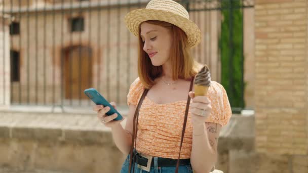 Młoda Ruda Kobieta Turysta Pomocą Smartfona Jedząc Lody Ulicy — Wideo stockowe