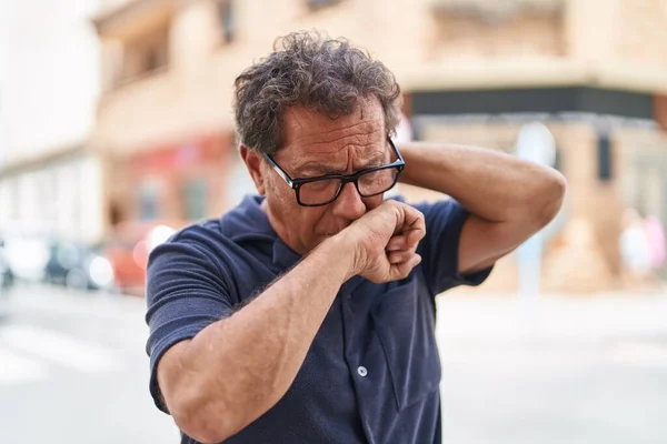 Middle age man coughing at street