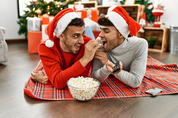 Two Hispanic Men Couple Watching Movie Lying Christmas Tree Home — ストック写真