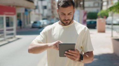 Sokakta dokunmatik ped kullanan, kendine güvenen İspanyol genç adam.