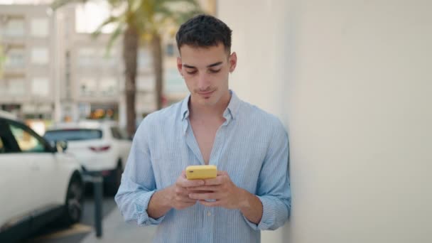 Joven Hispano Usando Smartphone Con Expresión Seria Calle — Vídeo de stock