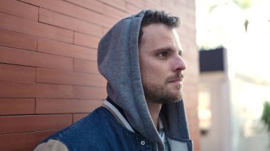 Young caucasian man standing wearing hoodie with serious expression at street