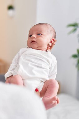 Adorable caucasian baby on mother hands at home