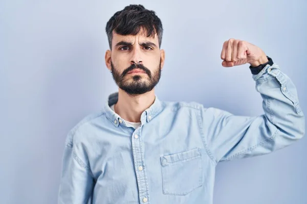 Young Hispanic Man Beard Standing Blue Background Strong Person Showing — 스톡 사진