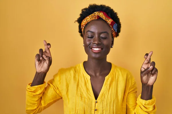 African Young Woman Wearing African Turban Gesturing Finger Crossed Smiling — ストック写真