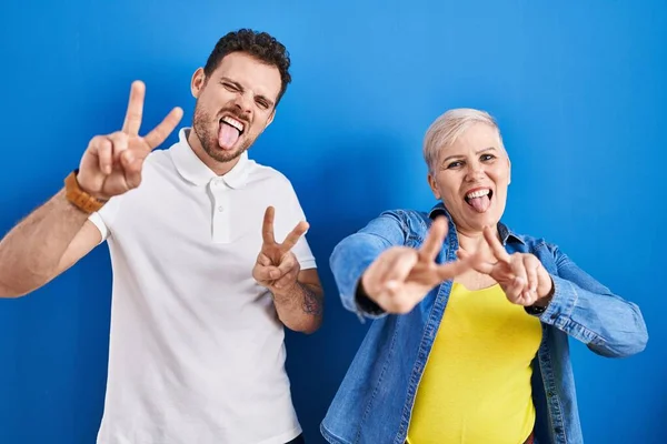 Young Brazilian Mother Son Standing Blue Background Smiling Tongue Out — Foto de Stock