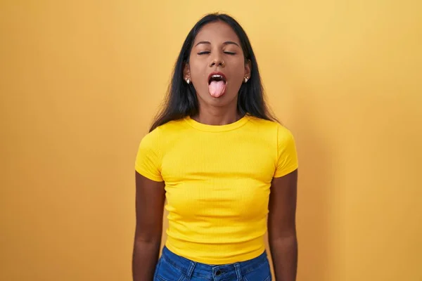 Young Indian Woman Standing Yellow Background Sticking Tongue Out Happy — Stockfoto
