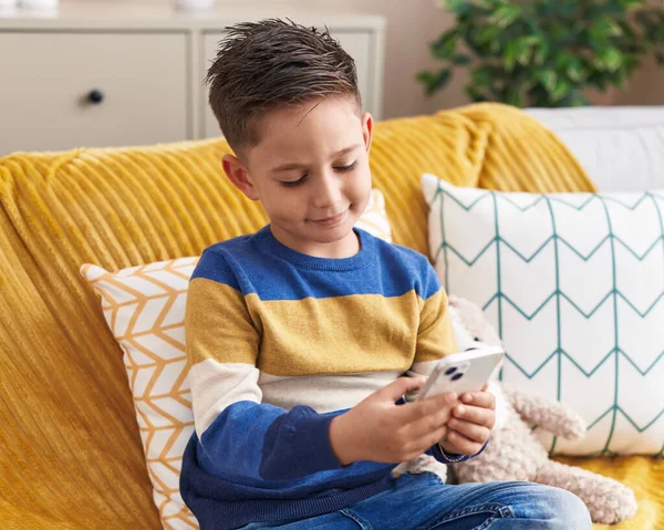 Adorable Hispanic Boy Using Smartphone Sitting Sofa Home — Zdjęcie stockowe