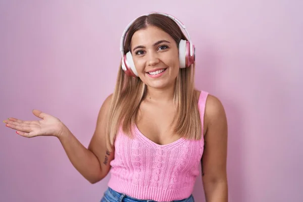 Young Blonde Woman Listening Music Using Headphones Smiling Cheerful Presenting — Stock Photo, Image