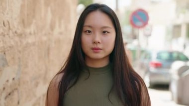 Young chinese woman smiling confident standing at street