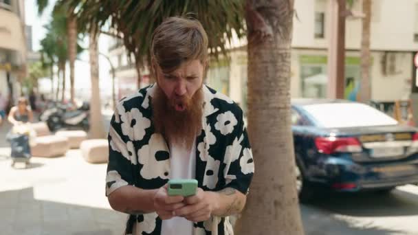 Young Redhead Man Using Smartphone Winner Expression Street — Stockvideo