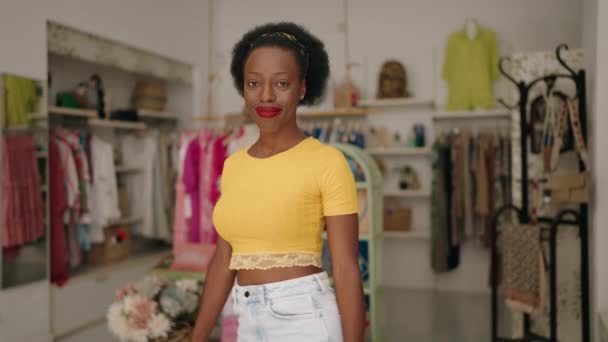 アフリカ系アメリカ人女性ショップアシスタント立っているとともに腕クロスジェスチャーで服店 — ストック動画