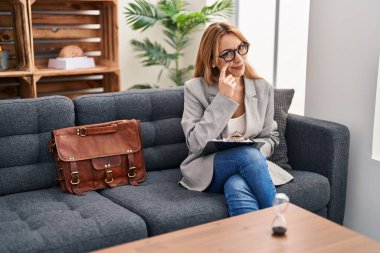 Hispanic woman working at consultation office pointing to the eye watching you gesture, suspicious expression 