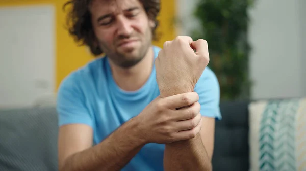 Young Hispanic Man Sitting Sofa Suffering Wrist Pain Home — Stock Photo, Image