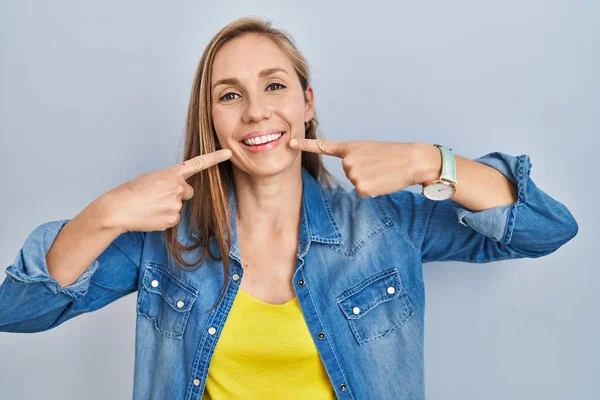 Young Blonde Woman Standing Blue Background Smiling Cheerful Showing Pointing — Foto Stock
