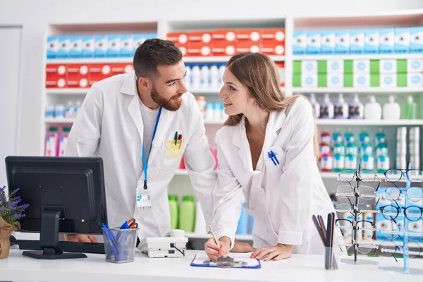 Man Woman Pharmacists Smiling Confident Writing Document Pharmacy — ストック写真