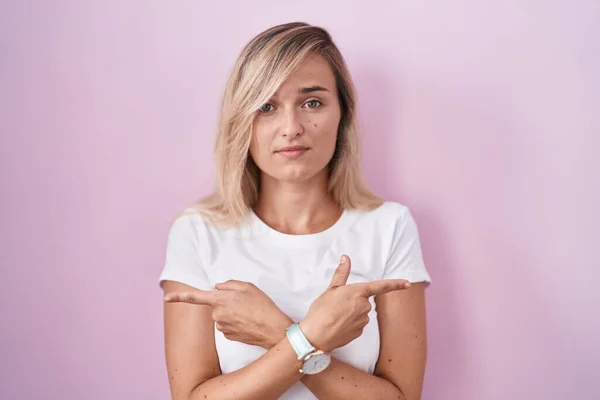 Young Blonde Woman Standing Pink Background Pointing Both Sides Fingers — Stock Photo, Image