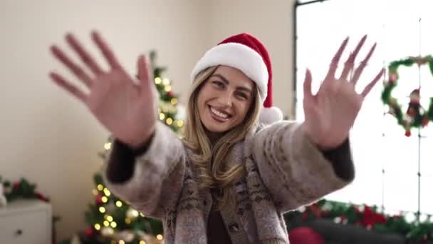 Evde Noel Ağacının Yanında Duran Genç Sarışın Kadın Merhaba Diyor — Stok video