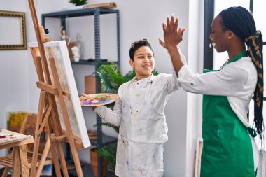 African american mother and son art student and teacher high five at art studio