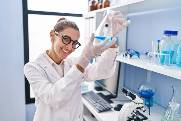 研究室で液体を測定する若い女性科学者 — ストック写真