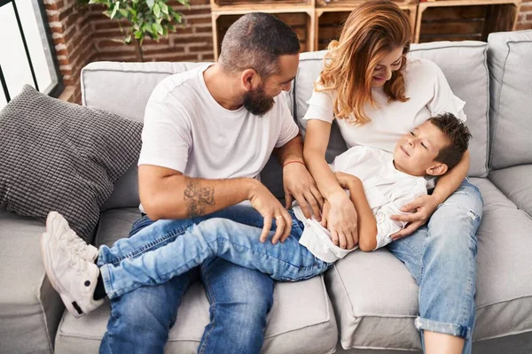 Family Doing Tickle Son Sitting Sofa Home — Zdjęcie stockowe