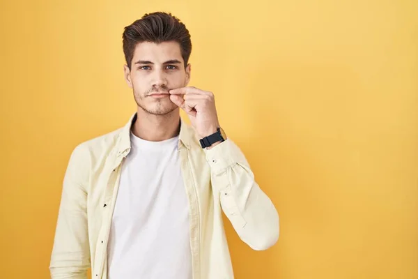 Sarı Arka Planda Dikilen Spanyol Genç Adam Ağzı Dudakları Parmaklarıyla — Stok fotoğraf