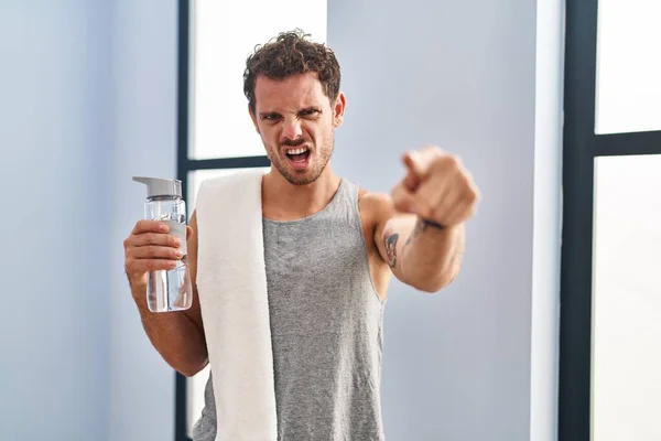 Young Hispanic Man Wearing Sportswear Drinking Water Pointing Displeased Frustrated — Stockfoto