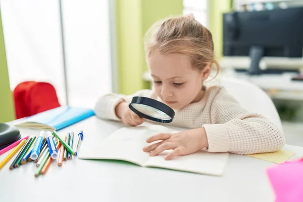 Adorable Blonde Girl Student Reading Book Using Magnifying Glass Classroom — Stockfoto