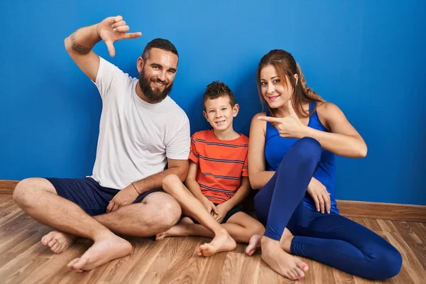 Family Three Sitting Floor Home Smiling Making Frame Hands Fingers — Stockfoto