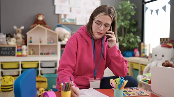 Young Blonde Woman Preschool Teacher Writing Document Talking Smartphone Kindergarten — 图库照片