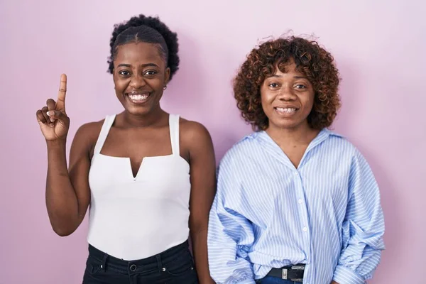 Zwei Afrikanische Frauen Stehen Vor Rosa Hintergrund Und Zeigen Mit — Stockfoto