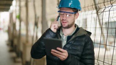 Genç mimar akıllı telefondan konuşuyor. Sokakta dokunmatik ped kullanıyor.