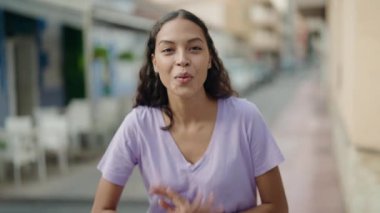Afro-Amerikalı genç bir kadın kahvecinin terasında kendinden emin bir şekilde gülümsüyor.